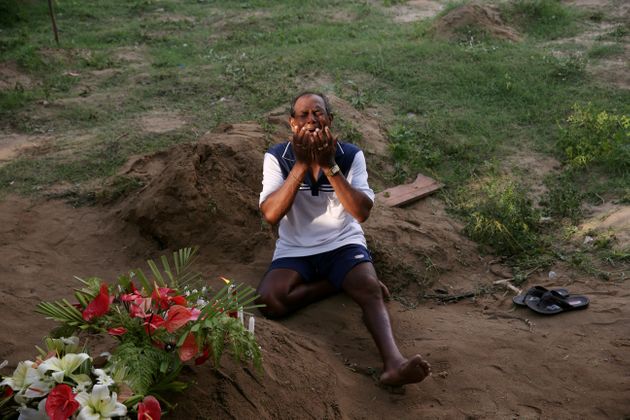 희생자가 묻힌 묘소 앞에서 한 남성이 오열하고 있다. 스리랑카, 네곰보. 2019년 4월23일.