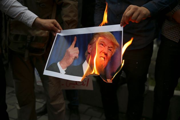 미국의 이란 핵협정 탈퇴 결정에 반발한 이란 시위대가 옛 미국 대사관 앞에서 도널드 트럼프 대통령의 사진을 불태우고 있다. 이란, 테헤란. 2018년 5월9일.