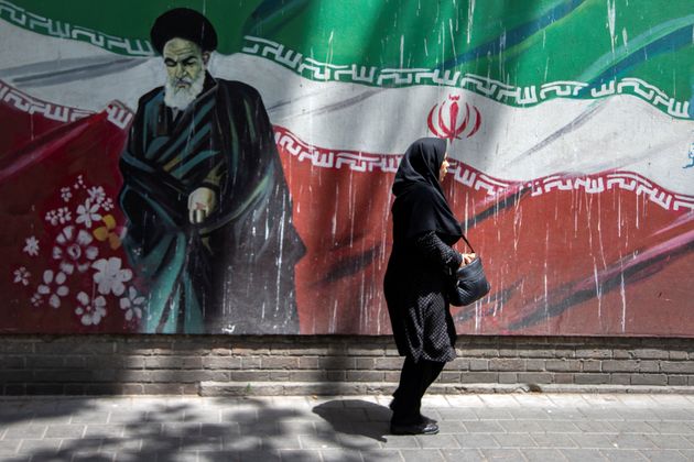 한 여성이 이란 혁명을 이끌었던 최고지도자 아야톨라 루홀라 호메이니(1902-1989) 벽화 앞을 걸어가고 있다. 테헤란, 이란. 2019년 7월7일.