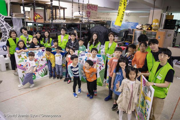 아이들과 그린피스 활동가가 함께 완성한 '미래 교통의 모습' 그림 앞에 서 있다