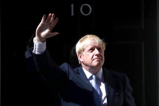 영국의 새 총리, 보리스 존슨이 집무실에 들어가기에 앞서 손을 흔들어보이고 있다. 런던, 영국. 2019년 7월24일.