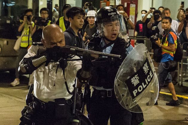 한 홍콩 경찰관이 콰이청 경찰서 인근에서 시위대를 향해 총을 겨누고 있다. 홍콩. 2019년 7월30일.