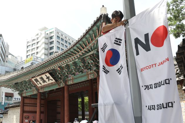 6일 오전 서울 중구 대한문 앞에서 중구청 관계자들이 태극기와 '노 재팬' 배너깃발을 설치하고 있다. 