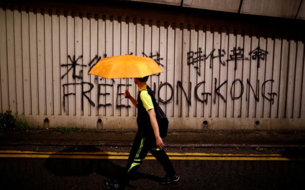 한 시민이 '홍콩에 자유를'이라는 낙서 옆을 지나가고 있다. 홍콩. 2019년 8월18일.