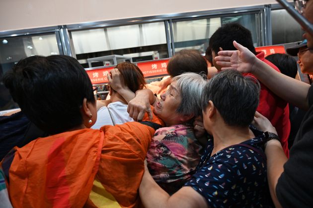 TOPSHOT - People try to get a roast chicken at the first Costco outlet in China, on the stores opening day in Shanghai on August 27, 2019. - China has proved a brutal battleground for overseas food retailers in recent years, with many failing to understand consumer habits and tastes as well as local competitors building a stronger presence. (Photo by HECTOR RETAMAL / AFP)        (Photo credit should read HECTOR RETAMAL/AFP/Getty Images)