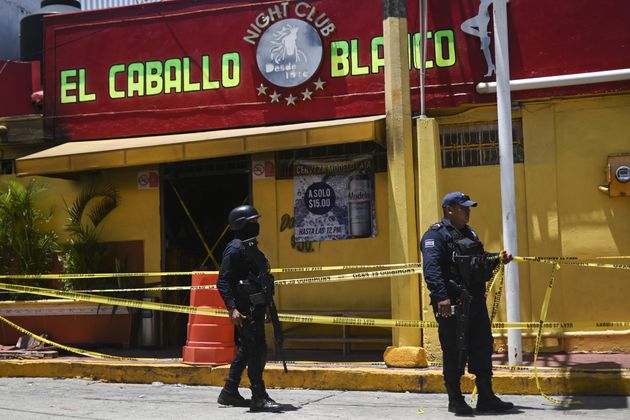 Police officers stand guard outside Caballo Blanco bar (White Horse bar) on August 28, 2019 where at least 26 people were killed and 11 badly wounded on the eve after gunmen trapped revellers inside the Caballo Blanco bar (White Horse bar) and started a raging fire. - President Andres Manuel Lopez Obrador condemned the 'shameful' attack and said federal authorities would investigate evidence it may have stemmed from collusion between local authorities and organized crime. (Photo by Pedro PARDO / AFP)        (Photo credit should read PEDRO PARDO/AFP/Getty Images)