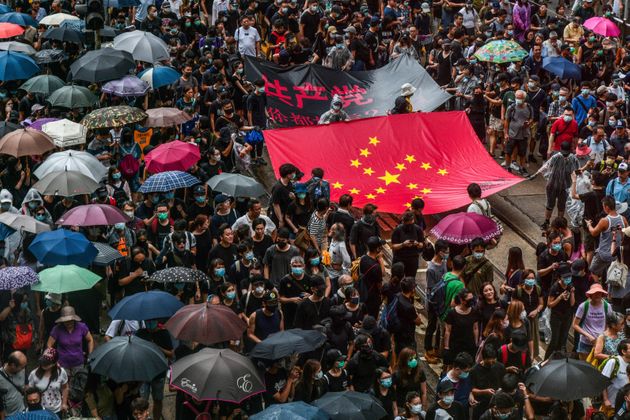 TOPSHOT - Protesters march with a banner that uses the stars of the Chinese national flag to depict a Nazi Swastika symbol in the Central district of Hong Kong on August 31, 2019. - Thousands of pro-democracy protesters defied a police ban on rallying in Hong Kong on August 31, a day after several leading activists and lawmakers were arrested in a sweeping crackdown. (Photo by Anthony WALLACE / AFP)        (Photo credit should read ANTHONY WALLACE/AFP/Getty Images)