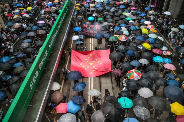 Protesters march with a banner that uses the stars of the Chinese national flag to depict a Nazi Swastika symbol in the Central district of Hong Kong on August 31, 2019. - Thousands of pro-democracy protesters defied a police ban on rallying in Hong Kong on August 31, a day after several leading activists and lawmakers were arrested in a sweeping crackdown. (Photo by Anthony WALLACE / AFP)        (Photo credit should read ANTHONY WALLACE/AFP/Getty Images)
