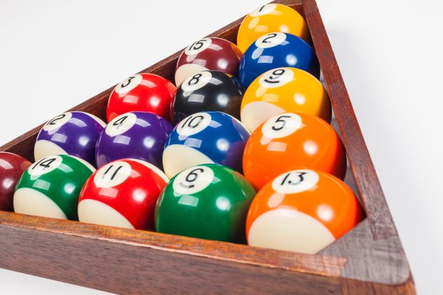 Close up of pool balls in a triangle on a white background