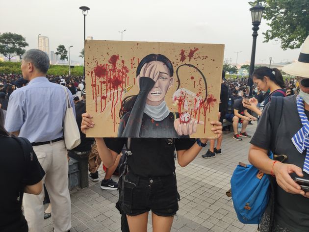 HONG KONG, CHINA - AUGUST 22: A high-school student holds an image, depicting a woman who lost an eye, at a rally in Hong Kong, China on August 22, 2019. Large-scale protests in Hong Kong began last June against a bill to legalize the extradition of suspects to mainland China, Macao and Taiwan. (Photo by Fuat Kabakci/Anadolu Agency via Getty Images)