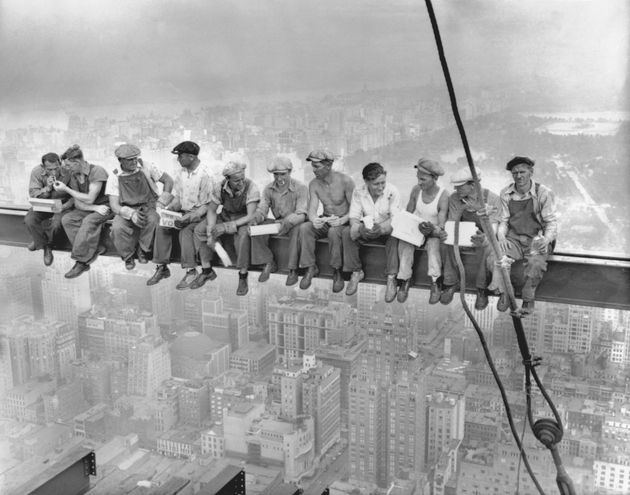 While New York's thousands rush to crowded restaurants and congested lunch counters for their noon day lunch, these intrepid steel workers atop the 70 story RCA building in Rockefeller Center get all the air and freedom they want by lunching on a steel beam with a sheer drop of over 800 feet to the street level. The RCA building is the largest office building in terms of office space in the world. (original caption). Image taken 9/20/32; filed 9/29/32.