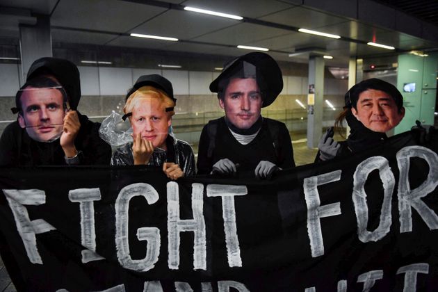 Protesters wearing masks of (L-R) French President Emmanuel Macron, British Prime Minister Boris Johnson, Canadian Prime Minister Justin Trudeau and Japan's Prime Minister Shinzo Abe display a banner during a rally at Tamar Park in Hong Kong on September 2, 2019, in the latest opposition to a proposed extradition law that has since morphed into a wider call for democratic rights in the semi-autonomous city. - Thousands of black-clad students rallied on September 2 at the start of a two-week boycott of university classes, piling pressure on Hong Kong's leaders to resolve months of increasingly violent anti-government protests that show no sign of easing. (Photo by Lillian SUWANRUMPHA / AFP)        (Photo credit should read LILLIAN SUWANRUMPHA/AFP/Getty Images)