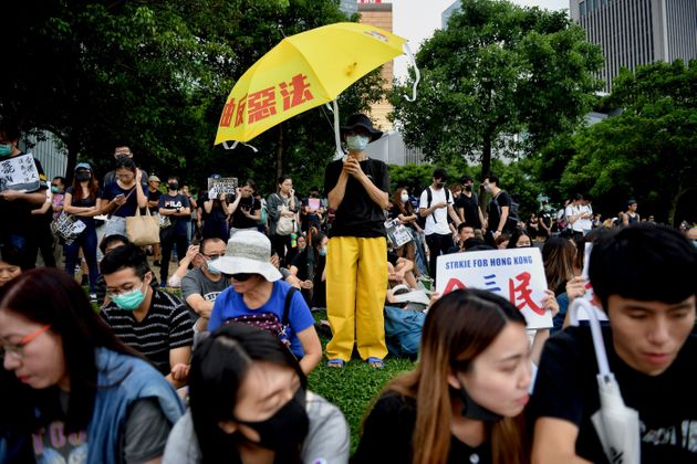 TOPSHOT - A protester (C) holds an umbrella in the latest rally against a controversial extradition bill at Tamar Park in the Admiralty district of Hong Kong on September 2, 2019. - Thousands of black-clad students rallied on September 2 at the start of a two-week boycott of university classes, piling pressure on Hong Kong's leaders to resolve months of increasingly violent anti-government protests that show no sign of easing. (Photo by Lillian SUWANRUMPHA / AFP)        (Photo credit should read LILLIAN SUWANRUMPHA/AFP/Getty Images)