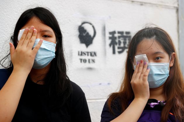 Students cover their eyes as they protest at Edinburgh Place in Hong Kong, China September 2, 2019. REUTERS/Kai Pfaffenbach