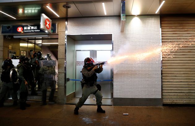 A riot police officer fires a tear gas canister during a rally in Central, Hong Kong, China September 8, 2019. REUTERS/Kai Pfaffenbach