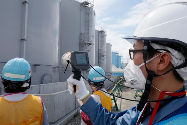 TOPSHOT - In this picture taken on July 27, 2018 and made available on July 30, 2018, a staff member of Tokyo Electric Power Company measures radiation levels around the storage tanks of radiation-contaminated water at the tsunami-crippled Tokyo Electric Power Company (TEPCO) Fukushima Dai-ichi nuclear power plant in Okuma, Fukushima prefecture. - The Fukushima nuclear disaster was triggered by a massive earthquake and ensuing tsunami in March 2011, which wrecked cooling systems at the plant on Japan's northeast coast, sparking reactor meltdowns and radiation leaks. (Photo by Kimimasa MAYAMA / POOL / AFP)        (Photo credit should read KIMIMASA MAYAMA/AFP/Getty Images)