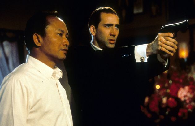 Director John Woo watches as Nicolas Cage aims pistol in between scenes from the film 'Face/Off', 1997. (Photo by Touchstone/Getty Images)