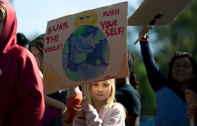 A student holds a sign while participating in a 'Global Climate Strike' at the Experiential School of Greensboro in Greensboro, N.C., on Friday, Sept. 20, 2019. Across the globe hundreds of thousands of young people took the streets Friday to demand that leaders tackle climate change in the run-up to a U.N. summit. (Khadejeh Nikouyeh/News & Record via AP)