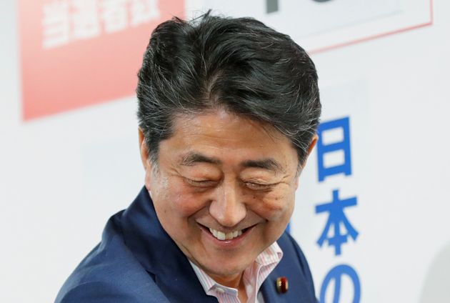 Japan's Prime Minister Shinzo Abe, who is also leader of the ruling Liberal Democratic Party (LDP), reacts as he puts a rosette on the name of a candidate who is expected to win the upper house election, at the LDP headquarters in Tokyo, Japan, July 21, 2019. REUTERS/Kim Kyung-Hoon