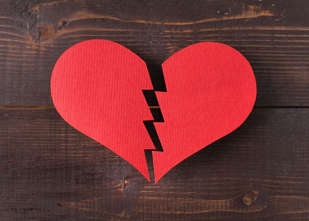 Paper broken heart on wooden background