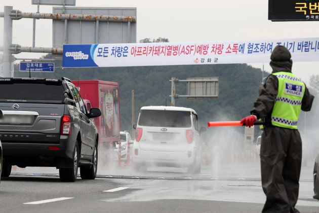 26일 경기도 김포시에서 강화도로 가는 진입로에서 차량 방역작업이 실시되고 있다.