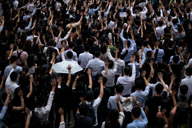 People display opened palm with five fingers, signifying the five demands of anti-government protesters during a march at Central district in Hong Kong, Wednesday, Oct. 2, 2019. Thousands marched in the business district denouncing the police shooting of a teenage protester during widespread anti-government demonstrations that marred China's National Day. (AP Photo/Felipe Dana)