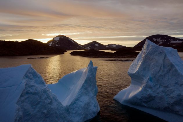 FILE - This early Friday, Aug. 16, 2019 file photo shows an aerial view of large Icebergs floating as the sun rises near Kulusuk, Greenland. Greenland has been melting faster in the last decade, and this summer, it has seen two of the biggest melts on record since 2012. A special United Nations-affiliated oceans and ice report released on Wednesday, Sept. 24, 2019 projects three feet of rising seas by the end of the century, much fewer fish, weakening ocean currents, even less snow and ice, and nastier hurricanes, caused by climate change. (AP Photo/Felipe Dana)