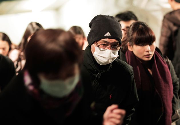 TOKYO, JAPAN - FEBRUARY 13:  Commuters in Tokyo wear surgical masks to help protect themselves from the influenza outbreak on February 13, 2012 in Tokyo, Japan. As the number of influenza patients is reported to have reached 2 million in Japan, Japanese passengers were quarantined by New Zealand authorities on an incoming flight at Auckland airport on monday after they displayed flu like symptoms.  (Photo by Adam Pretty/Getty Images)