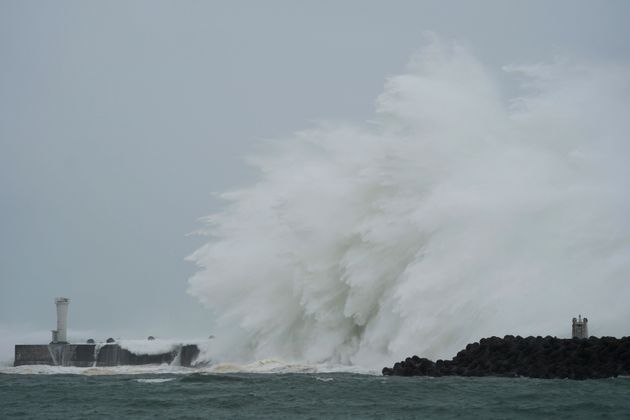 Surging waves hit against the breakwater and a lighthouse as Typhoon Hagibis approaches at a port in town of Kiho, Mie prefecture, central Japan Saturday, Oct. 12, 2019. Tokyo and surrounding areas braced for a powerful typhoon forecast as the worst in six decades, with streets and trains stations unusually quiet Saturday as rain poured over the city. (AP Photo/Toru Hanai)