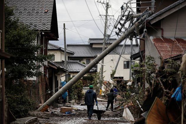 Residents walk along the mud-covered road in a neighborhood devastated by Typhoon Hagibis Tuesday, Oct. 15, 2019, in Nagano, Japan. More victims and more damage have been found in typhoon-hit areas of central and northern Japan, where rescue crews are searching for people still missing. (AP Photo/Jae C. Hong)