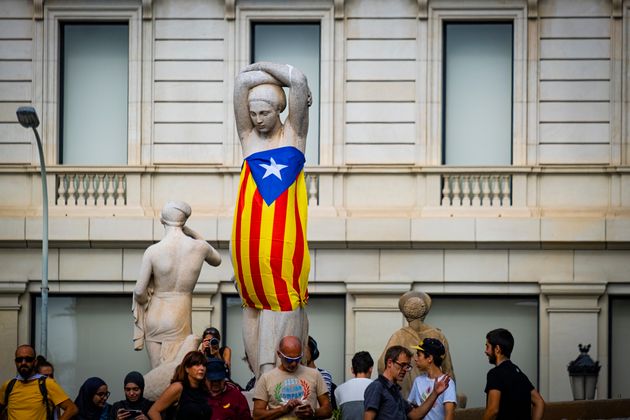 BARCELONA, CATALONIA, SPAIN - 2019/10/14: An independence flag is being wrapped around one of the popular sculptures of women in Plaza Catalunya during the demonstration.
After knowing the sentence of sedition and embezzlement issued by the Spanish courts with sentences between 9 and 13 years in prison for the leaders of the independence process in Catalonia, thousands of protesters have concentrated on the streets awaiting the first mass action. (Photo by Paco Freire/SOPA Images/LightRocket via Getty Images)