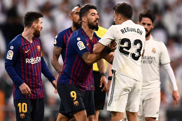 Barcelona's Uruguayan forward Luis Suarez (C) pushes Real Madrid's Spanish defender Sergio Reguilon during the Spanish league football match between Real Madrid CF and FC Barcelona at the Santiago Bernabeu stadium in Madrid on March 2, 2019. (Photo by OSCAR DEL POZO / AFP)        (Photo credit should read OSCAR DEL POZO/AFP/Getty Images)
