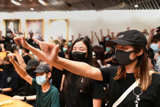 Student protesters gesture in a meeting room after forcing their way into the administrative offices at the Chinese University of Hong Kong (CUHK) to demand to speak to the school chairman in Hong Kong on October 3, 2019. - Anger continued to mount over the police shooting of a teenage protester on October 1 who attacked officers, in a dramatic escalation of the violent unrest that has engulfed the territory for months. (Photo by Mohd RASFAN / AFP) (Photo by MOHD RASFAN/AFP via Getty Images)
