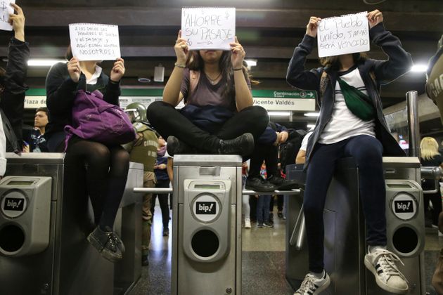 지난 18일 아직 시위가 격화되기 전 산티아고의 학생들이 '우리가 낸 돈으로 월급을 받는 경찰과 지하철 공공서비스가 우리를 막고 있다', '티켓 요금을 내지 마세요' 등의 푯말을 들고 있다. 