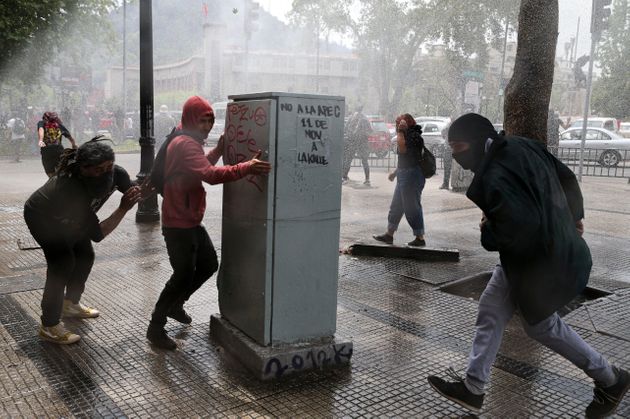 지난 19일 경찰의 물대포를 피하는 산티아고의 시위대들. 