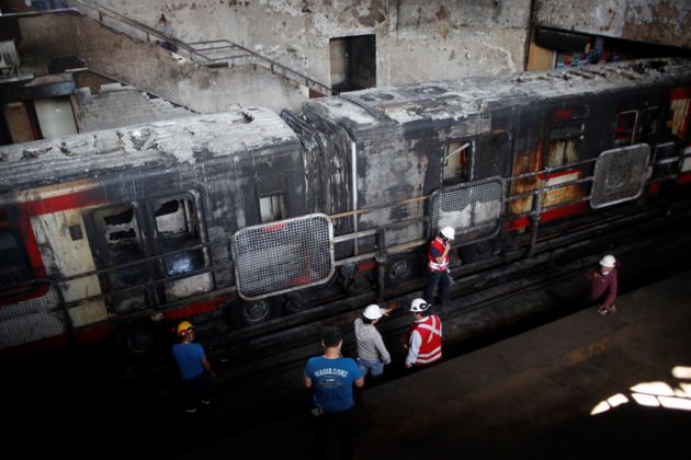 지난 20일 상파블로 역에서 불에 탄 기차를 소방 대원들이 확인하고 있다. 