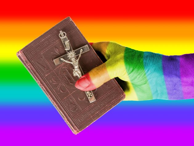 Old hand (woman) holding a very old bible, isolated on white, rainbow flagHand (woman) holding a very old bible, isolated on white, rainbow flag