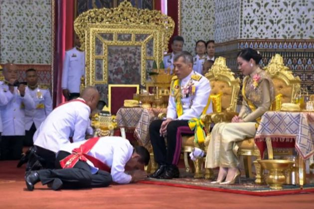 This screengrab from Thai TV Pool video taken on May 5, 2019 shows Thailand's Prime Minister Prayut Chan-O-Cha (L) paying respect to Thailand's King Maha Vajiralongkorn (C) while Queen Suthida looks on following the coronation ceremony at the Grand Palace in Bangkok. - Thai King Maha Vajiralongkorn was crowned on May 4 with a golden-tiered headpiece, the highlight of an elaborate three-day coronation ceremony two years after he ascended the throne. (Photo by Thai TV Pool / THAI TV POOL / AFP)        (Photo credit should read THAI TV POOL/AFP/Getty Images)