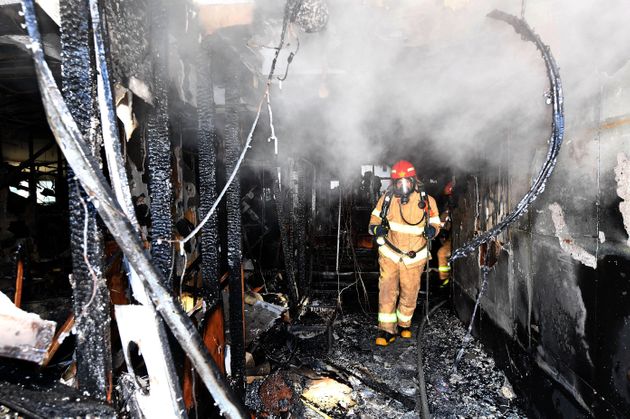 MIRYANG, SOUTH KOREA - JANUARY 26:  (SOUTH KOREA OUT) In this handout image provided by the Kyungnam Shinmun, Firefighter inspects a burnt hospital after a fire on January 26, 2018 in Miryang, South Korea. 37 people were killed in a fire at a hospital in the southeastern city of Miryang early Friday, with the number of casualties likely to rise further.  (Photo by Kyungnam Shinmun via Getty Images)