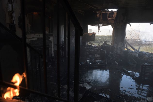 A burnt house lays flooded as leftover flames from the Tick fire continue to burn in the Santa Clarita, Calif. on Thursday, Oct. 24, 2019 (AP Photo/ Christian Monterrosa)