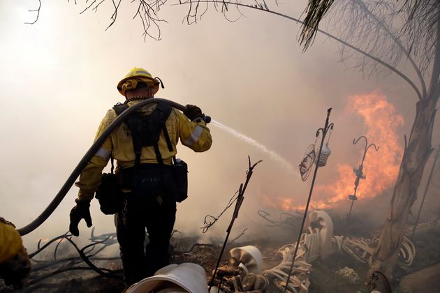 A firefighter makes a stand as a wildfire approaches the backyard of a home Thursday, Oct. 24, 2019, in Santa Clarita, Calif. (AP Photo/Marcio Jose Sanchez)