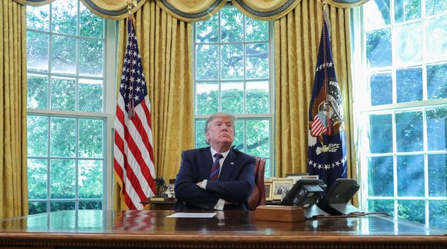 U.S. President Donald Trump listens to a question from the news media as he sits behind the Resolute Desk in the Oval Office of the White House in Washington, U.S., July 26, 2019. REUTERS/Leah Millis