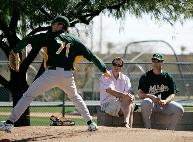 Oakland Athletics' general manager Billy Beane, center, and manager Bob Geren, right, watch as pitcher David Shafer throws during their spring training baseball workout in Phoenix, Saturday, Feb. 17, 2007.  (AP Photo/Eric Risberg)