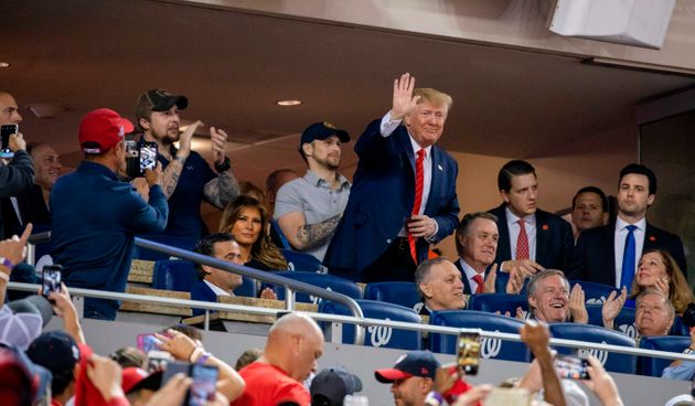 US President Donald Trump (C) waves as US First Lady Melania Trump looks on as they watch Game 5 of the World Series between the Washington Nationals and Houston Astros at Nationals Park in Washington, DC on October 27, 2019. (Photo by TASOS KATOPODIS / AFP) (Photo by TASOS KATOPODIS/AFP via Getty Images)
