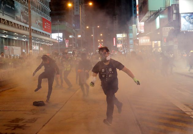 A demonstrator runs to throw back a tear gas canister to riot police during an anti-government protest in Hong Kong, China October 27, 2019. REUTERS/Kim Kyung-Hoon