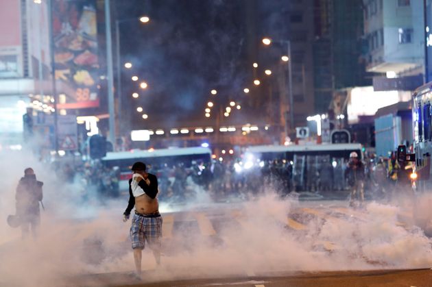 A man runs among the tear gas during a protest in Hong Kong's tourism district of Tsim Sha Tsui, China October 27, 2019. REUTERS/Kim Kyung-Hoon