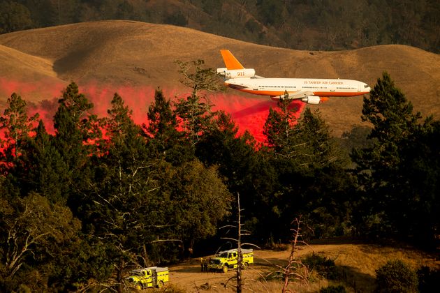 An air tanker drops retardant while battling the Kincade Fire in unincorporated Sonoma County, Calif., near Geyservillle on Saturday, Oct. 26, 2019. The blaze forced evacuations orders for nearly all of Sonoma County stretching to the coast, with forecasts of strong winds prompting officials to start cutting electricity for millions of people in an effort to prevent more fires. (AP Photo/Noah Berger)