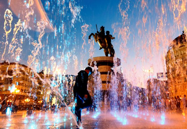 People play with water from a fountain near the 'Warrior on a horse' monument in Skopje, North Macedonia October 22, 2019. REUTERS/Ognen Teofilovski     TPX IMAGES OF THE DAY