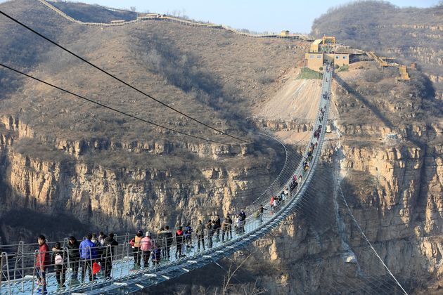 Visitors walk on the newly opened 488-metre-long glass suspension bridge at Hongyagu attraction in Pingshan, Hebei province, China December 26, 2017. Picture taken December 26, 2017. Zhang Haiqiang via REUTERS   ATTENTION EDITORS - THIS IMAGE WAS PROVIDED BY A THIRD PARTY. CHINA OUT.
