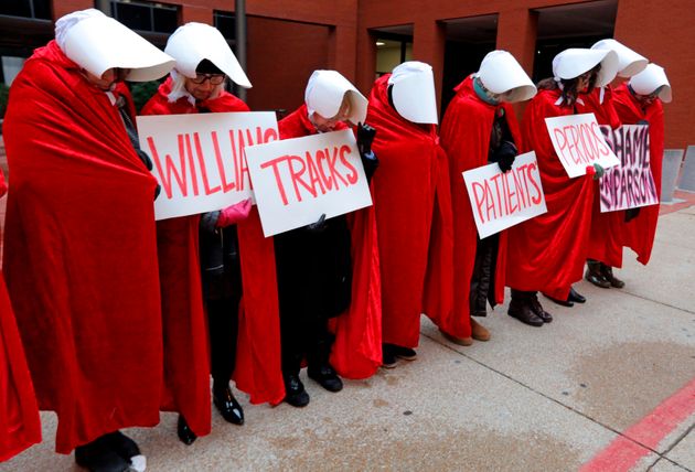 Planned Parenthood supporters, dressed In 'The Handmaid's Tale' costumes, stand in silence before the fourth day of hearings between Planned Parenthood and Missouri Department of Health and Senior Services on whether Planned Parenthood can keep its abortion license on Thursday, Oct. 31, 2019, in St. Louis.  (Laurie Skrivan/St. Louis Post-Dispatch via AP)